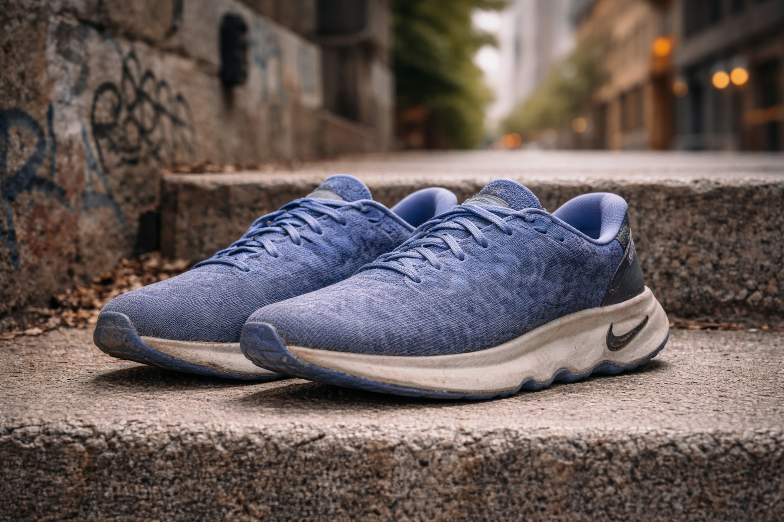 A pair of weathered shoes on steps in a city.